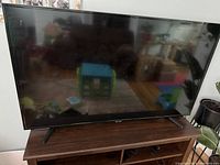 Front view of the TV on its stand showing the display and bezel