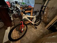 Front and side view of CCM mountain bike showing white frame, red fork, front tire and handlebars with controls