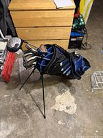 Black and blue stand golf bag with golf clubs inside, viewed from above and to the side, showing club heads and bag details.