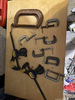 Photo of lot showing 10 C clamps of various sizes and types on wooden table.