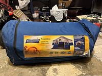 Blue duffel-style carry bag with label showing model and branding