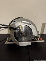 Side angle view of the Maximum 10-inch circular saw showing blade and brand marking on blade guard.