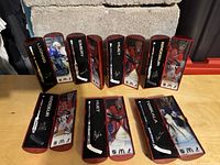 Photo showing all 8 miniature goalie sticks standing and lying flat, each with player names and images visible in red and black display boxes.