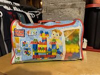 Branded Mega Bloks First Builders storage bag with colorful cartoon design, showing set branding and artwork.