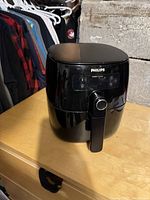 Philips air fryer closed, showing front digital control panel and handle.