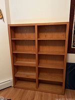 Solid wood blonde bookshelf with two vertical sections and four shelves per section.