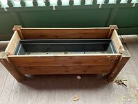 Top-down and angled photos showing rectangular wood planter with black plastic insert inside. Planter dimensions approximately 38x15x16 inches.