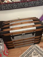 Closed view of the exterior of the wood steamer trunk showing wooden slats and metal accents.