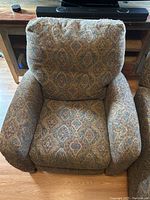 Photo of one recliner chair from the front showing seat, armrests, and back.