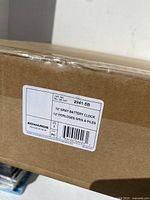 Close-up photo of the label on the box showing product details: 12" Gray Battery Clock by Edwards, model 2941-5B.