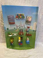 Front view of the entire store display with attached Super Mario toys, showing the colorful backdrop and all attached figures and packages.