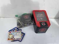 Photo showing the storage tin, a pile of mostly Chaotic cards along with some Pokémon-style cards fanned out