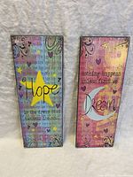 Front and back views of the two wall art pieces showing the inspirational texts and artwork, and the backing of one piece with a hanging mechanism.