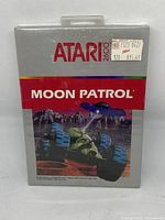 Front of sealed Moon Patrol Atari 2600 game box with artwork and Atari branding visible, showing a sticker with price $15.61.