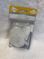 Packaged set of three transparent plastic outlet plug covers in original Angel of Mine branded packaging.