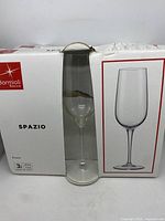 Box of Bormioli Rocco Spazio flute glasses with one glass visible through clear packaging, showing the elegant shape and stem design.