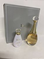 Two J'adore Dior items with original grey Dior box in background