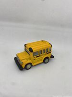 Mini yellow toy school bus angled to show front and left side, displaying overall shape and condition.