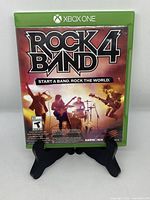 Front cover of Rock Band 4 Xbox One game case showing title and band performing on stage.