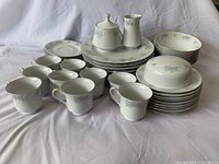 Photo of the entire china set showing all plates, cups, saucers, creamer, covered sugar bowl, and covered butter dish arranged together.