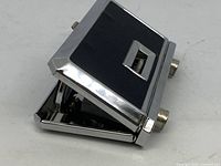 Angle view showing compact folded opera glasses with metal and black textured body.