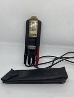 Full view of the voltage tester with test leads and carrying case laid out flat on white background