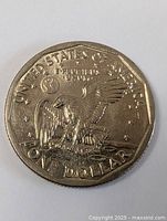 Reverse side showing an eagle with outstretched wings perched on a branch, surrounded by the text UNITED STATES OF AMERICA, E PLURIBUS UNUM, and ONE DOLLAR.