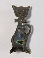 Front view of MCM sterling silver cat brooch pin displaying whimsical cat face and abalone shell inlay on body.