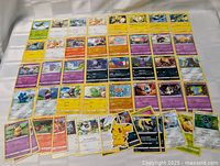 Top view of 50 Pokémon trading cards laid out showing artwork and detail of each card.