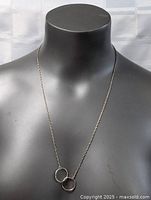 Full view of sterling silver necklace on display bust showing chain length and pendant