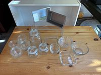 Wide view of the assortment of glass jars, bowls, and a metal baking pan on wooden table.