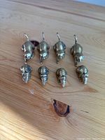 Top view of 4 brass cat and 4 brass mouse figurines arranged in rows on a wooden surface.