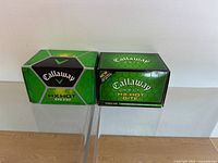 Two unopened boxes of Callaway HX Hot Bite2 golf balls displayed side by side showing their packaging and branding.