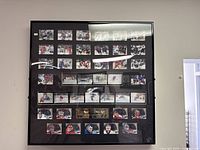 Front view of entire framed NHL hockey card collection with multiple rows of cards visible, plaque in middle, black frame and glass front.
