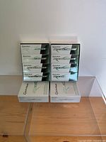 Stack of 8 full sleeves of TaylorMade RocketBallz2 golf balls shown in unopened boxes, stacked in two rows of four plus two at the bottom.