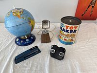 Photo showing all five vintage decor items: Blue Planet lamp, wooden lamp, Toy Maker kit, Swingline stapler, and viewfinder