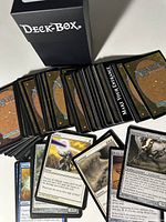 Photo showing many Magic the Gathering cards spread out alongside a black Ultra Pro Deck Box, illustrating the total number of cards and the storage case included.