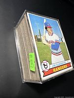 Stack of baseball cards with Jim Sundberg Texas Rangers card on top in protective sleeve.