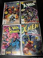 Four vintage 1990s X-Men comic books shown in clear protective sleeves, arranged in two rows on a black surface.