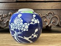 Photo of the ceramic bowl showing the blue background with white flower and branch design, showcasing its round shape and artistic detail.