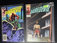 Photo showing two Daredevil comic books: Issue #167 with a cover price of 60 cents and featuring Daredevil in a fight with an archer; Issue #207 with a boxing ring scene and a man standing inside the ring.