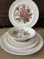 Set of floral porcelain plates and a bowl in varied sizes, showing front design and texture