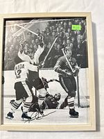 Full view of the framed photo depicting the 1972 Summit Series hockey game moment with Paul Henderson's signature visible.