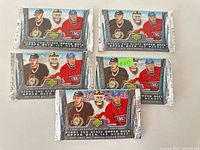 Front view of five sealed unopened 2007-2008 Upper Deck Ice Heroes hockey card packs, showing player images.