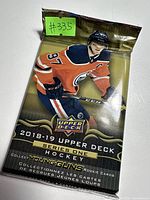 Front view of unopened 2018-19 Upper Deck Series One hockey card pack showing Edmonton Oilers player in orange jersey with gold and black design.