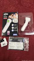 Braun no touch thermometer in original packaging including box and plastic inner tray with device and instruction leaflet.