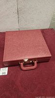 Closed red briefcase with textured material and handle