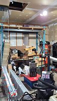 Wide view of shelving unit in a garage with various items stored on it.