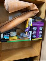 Shelf with rolled orange Schluter membrane and various hand tools and hardware boxes