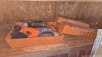 Orange Black & Decker work wheel and storage case on wooden surface